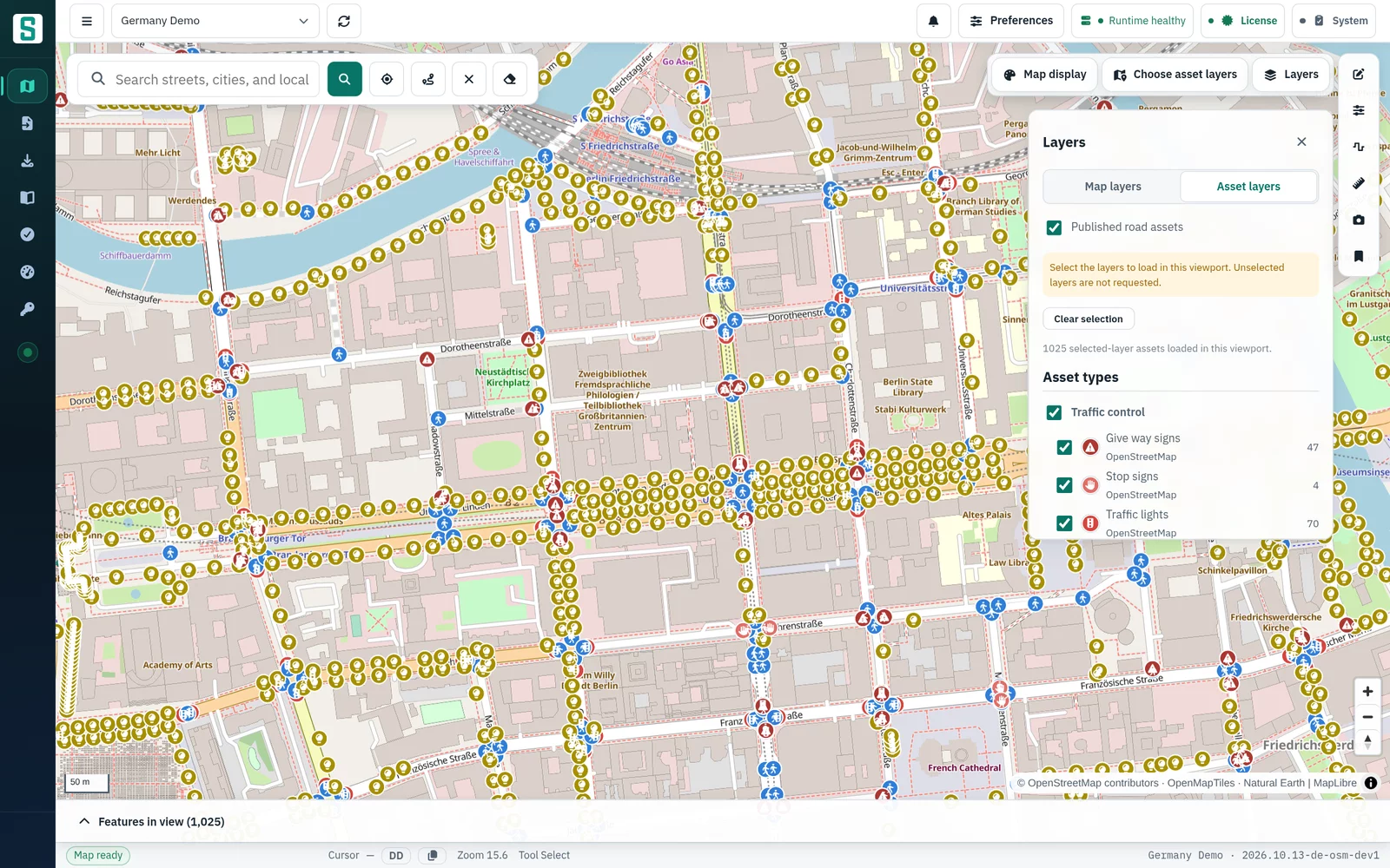 SenDevo GIS console showing central Berlin with traffic lights, crossings, street lights and give-way and stop signs as road-asset symbols, with the Layers panel open on asset layers